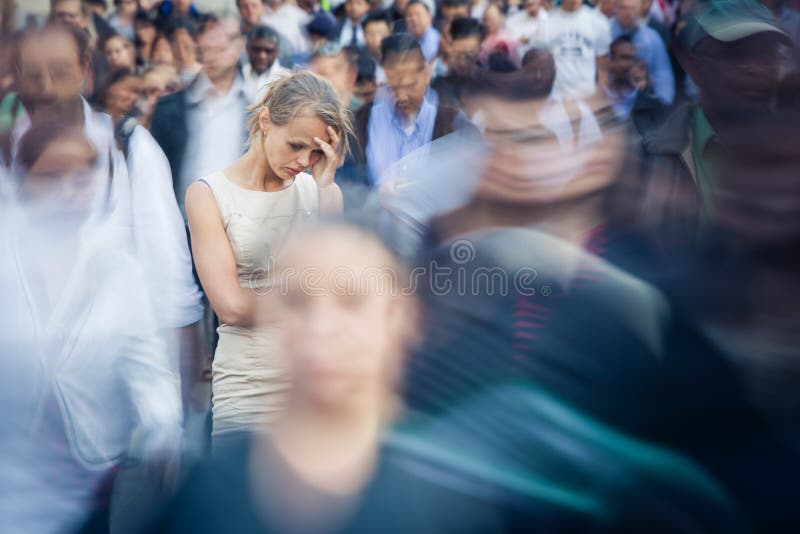 Depressed young woman feeling alone amid a crowd of people in a big city. Depressed young woman feeling alone amid a crowd of people in a big city