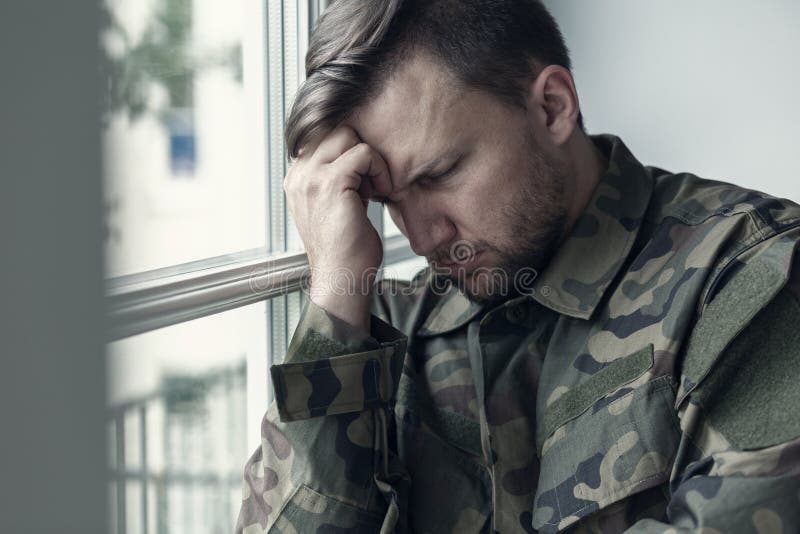 Przygnębiony i osamotniony żołnierz w wojskowym uniformu z wojennym syndromem zdjęcia stock Przygnębiony i osamotniony żołnierz w wojskowym uniformu z wojennym syndromem zdjęcia stock