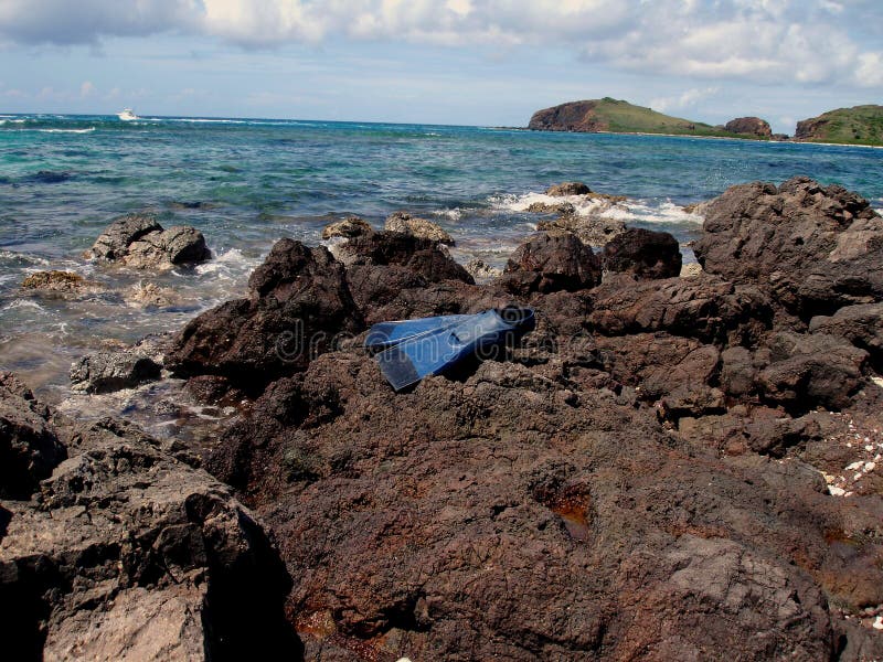 Fins, a travelers gear, lay on some boulders with a view of the islands in the background. Fins, a travelers gear, lay on some boulders with a view of the islands in the background