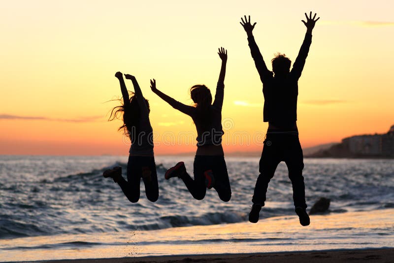 Three friends silhouettes jumping happy and raising arms on the beach at sunset. Three friends silhouettes jumping happy and raising arms on the beach at sunset