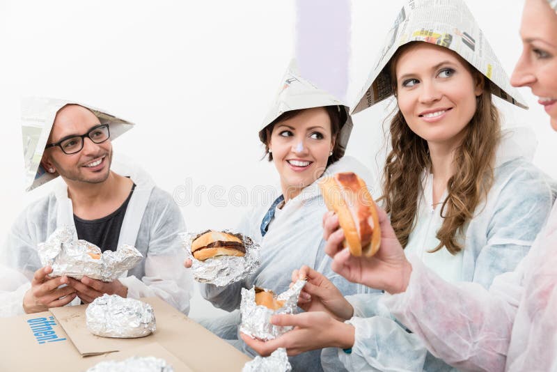 Przyjaciele cieszy się fast food przy nowym domem zdjęcia stock Przyjaciele cieszy się fast food przy nowym domem zdjęcia stock