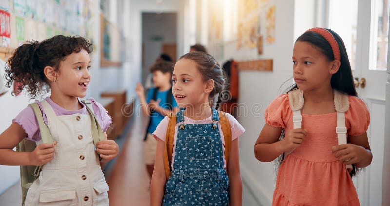 Przyjaciele dzieci i rozmawiający w korytarzu szkolnym w celach edukacyjnych lub edukacyjnych. Szczęśliwych dziewczyn koleżanek i zdjęcia stock