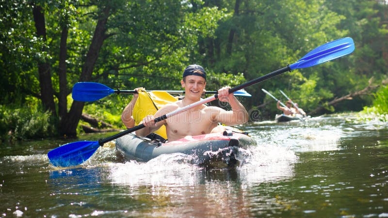 Przyjaciele ma szczęście podczas flisactwa na rzece Faceci w czółnie z paddles Wiosłować w łodzi przy weekendem zdjęcie royalty free Przyjaciele ma szczęście podczas flisactwa na rzece Faceci w czółnie z paddles Wiosłować w łodzi przy weekendem zdjęcie royalty free