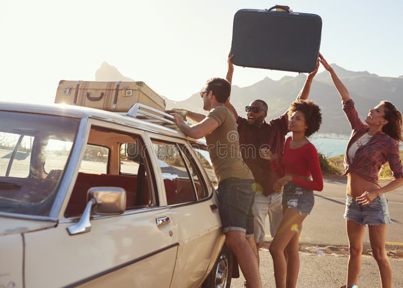 Przyjaciele Ładuje bagaż Na Samochodowym Dachowym stojaku Przygotowywającym Dla wycieczki samochodowej