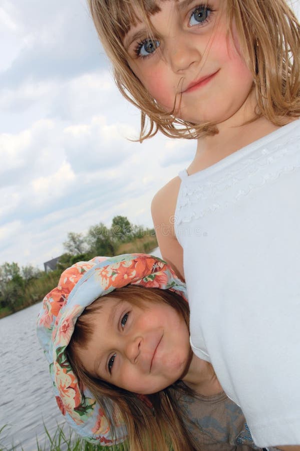 Adorable happy girls friends outdoor on the riverbank. Adorable happy girls friends outdoor on the riverbank