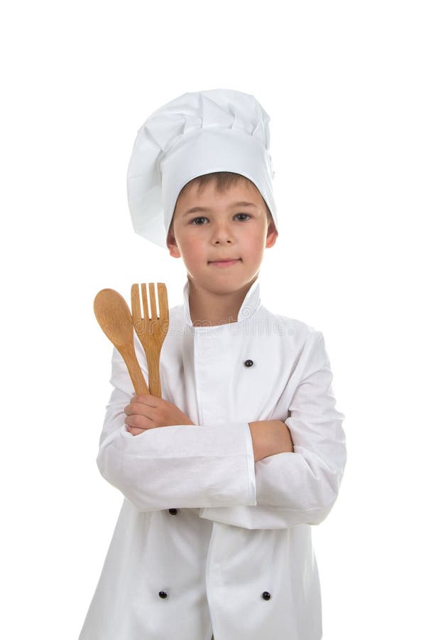 Przystojna chłopiec w szefa kuchni munduru mienia drewnianym cutlery, odizolowywającym na białym tle obrazy stock Przystojna chłopiec w szefa kuchni munduru mienia drewnianym cutlery, odizolowywającym na białym tle obrazy stock