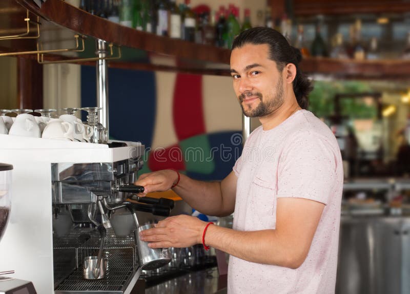 Przystojnego młodego uśmiechniętego męskiego barista narządzania napoju kawowy używać zdjęcia royalty free Przystojnego młodego uśmiechniętego męskiego barista narządzania napoju kawowy używać zdjęcia royalty free