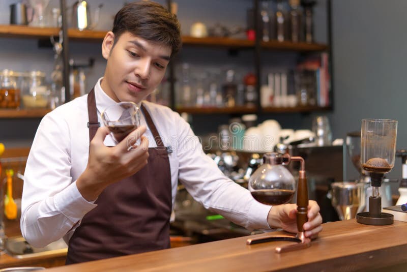 Przystojny caucasian barista trzyma filiżanki dolewania kawę z Syp zdjęcia stock Przystojny caucasian barista trzyma filiżanki dolewania kawę z Syp zdjęcia stock
