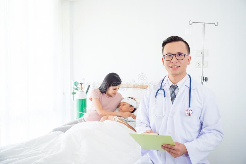 Przystojny doktorski ono uśmiecha się z pacjentem i rodziną w tle obraz stock Przystojny doktorski ono uśmiecha się z pacjentem i rodziną w tle obraz stock