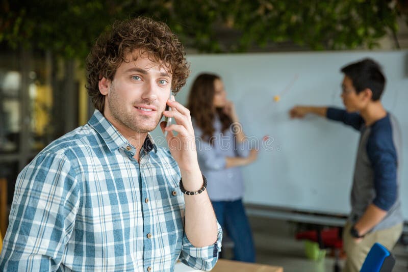 Przystojny facet opowiada na telefonie komórkowym przy biznesowym spotkaniem
