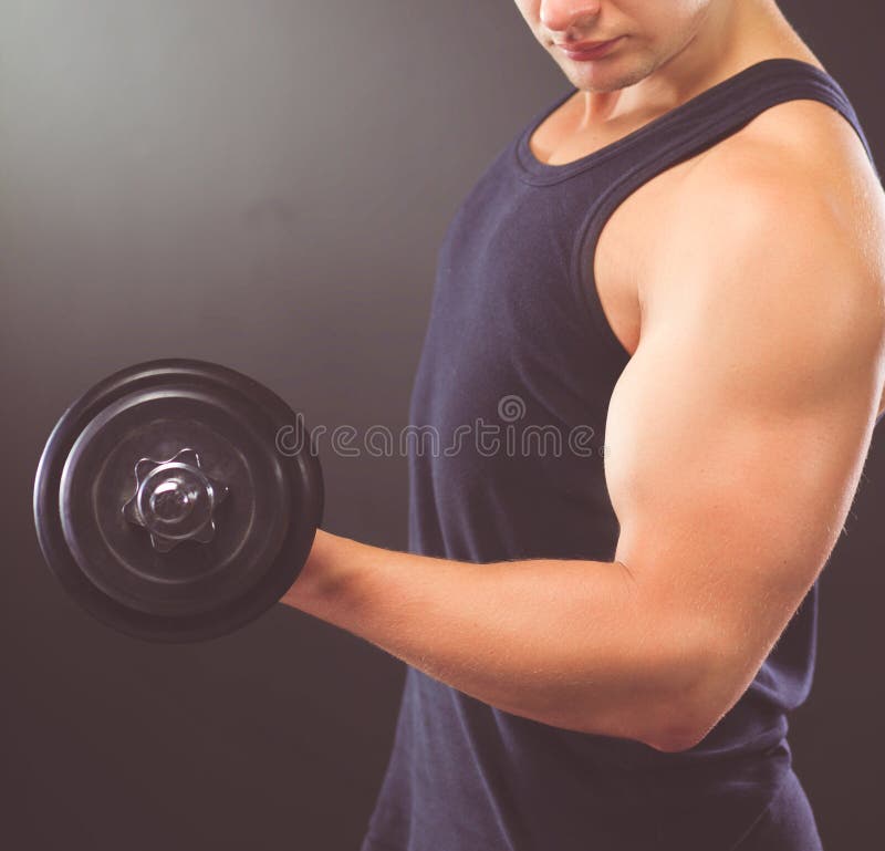 Przystojny mi??niowy m??czyzna pracuj?cy z dumbbells out fotografia royalty free Przystojny mi??niowy m??czyzna pracuj?cy z dumbbells out fotografia royalty free