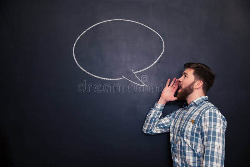 Przystojny mężczyzna krzyczy przeciw chalkboard tłu z patroszonym mowa bąblem zdjęcia royalty free Przystojny mężczyzna krzyczy przeciw chalkboard tłu z patroszonym mowa bąblem zdjęcia royalty free