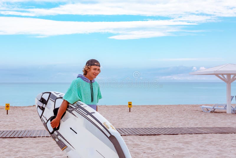 Przystojny mężczyzna spacer z białą pustą surfing deską czekać na fala surfować punkt przy dennym oceanu brzeg Widok od strony Po zdjęcie royalty free Przystojny mężczyzna spacer z białą pustą surfing deską czekać na fala surfować punkt przy dennym oceanu brzeg Widok od strony Po zdjęcie royalty free