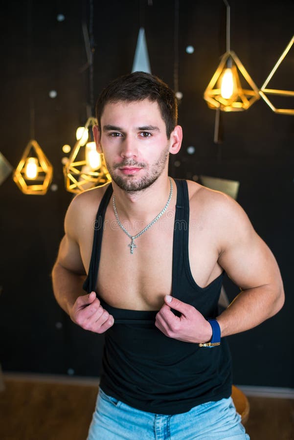 Przystojny mężczyzna w czarnym podkoszulku bez rękawów, pozuje, moda portret obraz stock Przystojny mężczyzna w czarnym podkoszulku bez rękawów, pozuje, moda portret obraz stock