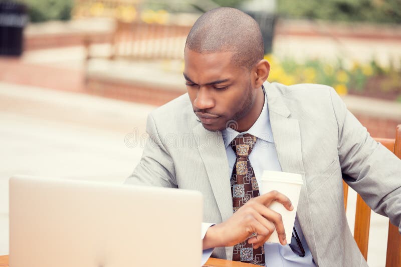 Przystojny rozważny młody biznesowy mężczyzna pracuje na laptopie outdoors obrazy stock Przystojny rozważny młody biznesowy mężczyzna pracuje na laptopie outdoors obrazy stock