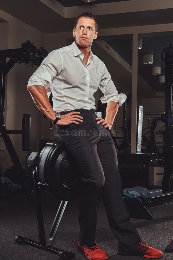 Przystojny ufny biznesmen w formalnych ubraniach przychodził gym dla trenować po tym jak ciężkiego dnia ` s praca fotografia royalty free Przystojny ufny biznesmen w formalnych ubraniach przychodził gym dla trenować po tym jak ciężkiego dnia ` s praca fotografia royalty free