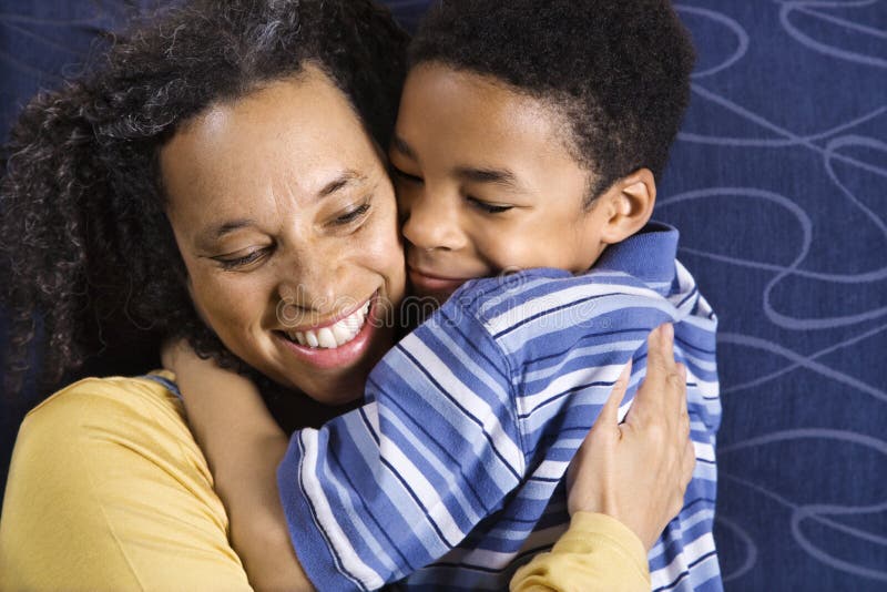 A mid adult African American woman affectionately hugging her young son. Horizontal shot. A mid adult African American woman affectionately hugging her young son. Horizontal shot.