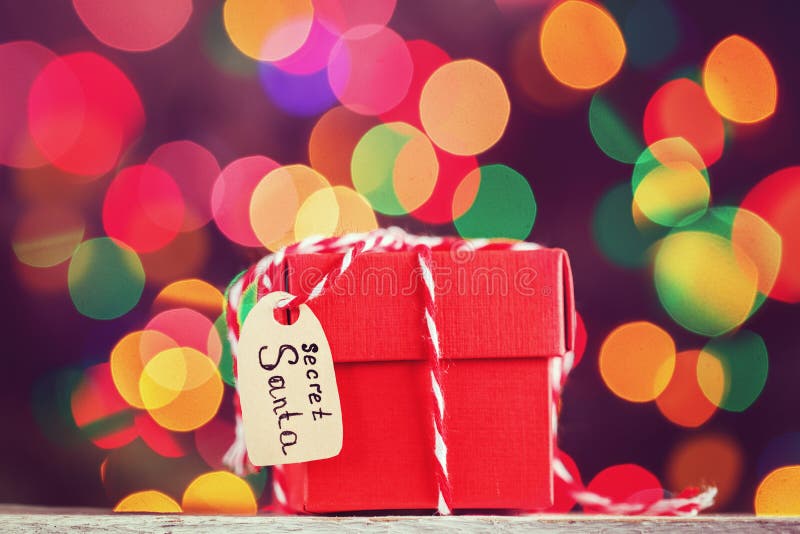 Présent ou boîte de rouge de Noël pour Santa secrète sur le fond coloré de bokeh Carte de voeux photographie stock libre de droits Présent ou boîte de rouge de Noël pour Santa secrète sur le fond coloré de bokeh Carte de voeux photographie stock libre de droits