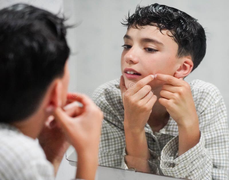 Préteen en pyjama prenant soin de sa peau jeune acné photographie stock