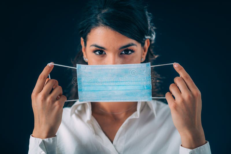 Coronavirus Disease Prevention. Beautiful Young Woman Putting Protective Mask On. Coronavirus Disease Prevention. Beautiful Young Woman Putting Protective Mask On