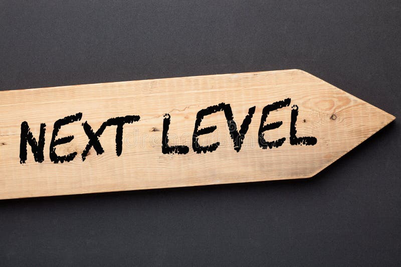 The text Next Level written on old wooden arrow on black background. The text Next Level written on old wooden arrow on black background