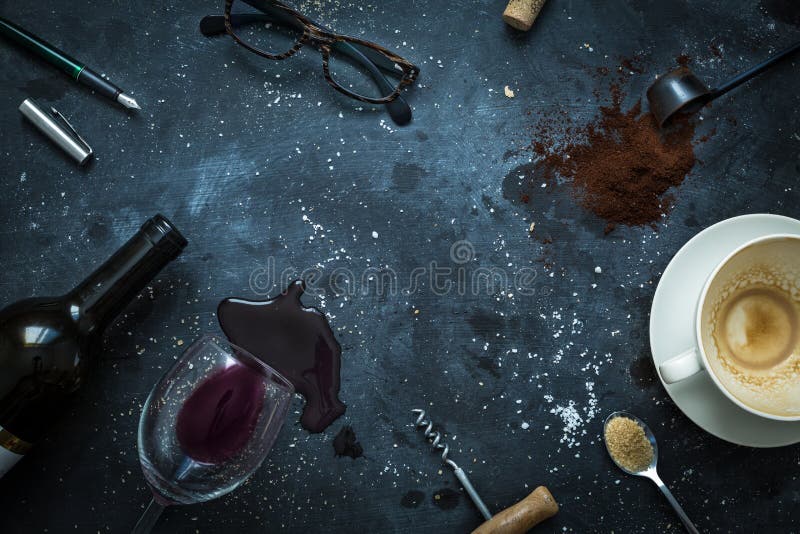 Messy bar table - empty coffee cup, spilled wine, glasses and pen. Writer`s desk scenery after late night work concept. Flat lay layout captured from above top view. Background with free text space. Messy bar table - empty coffee cup, spilled wine, glasses and pen. Writer`s desk scenery after late night work concept. Flat lay layout captured from above top view. Background with free text space.