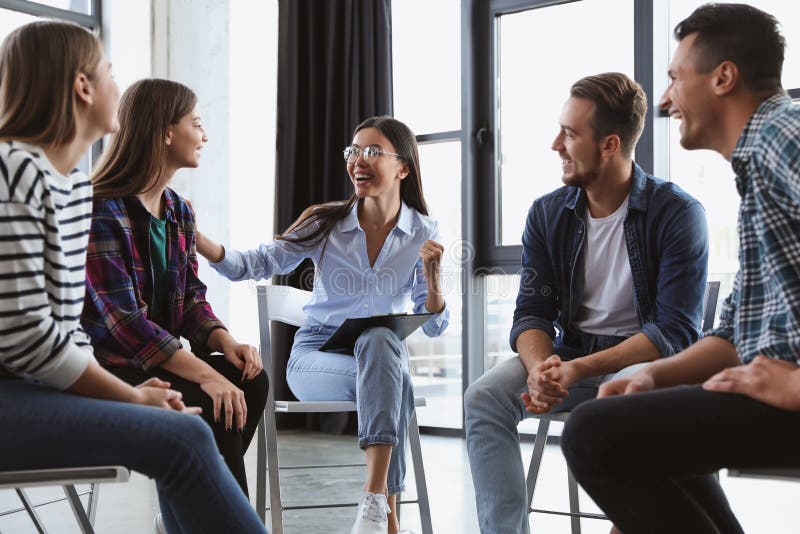 Psychotherapist working with patients in group therapy session indoors. Psychotherapist working with patients in group therapy session indoors