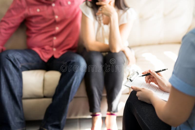 Psicólogo fêmea que faz anotações na sessão de terapia fotos de stock Psicólogo fêmea que faz anotações na sessão de terapia fotos de stock
