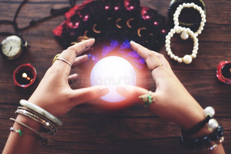 Psychic readings and clairvoyance concept Crystal ball fortune teller hands and Tarot cards reading divination