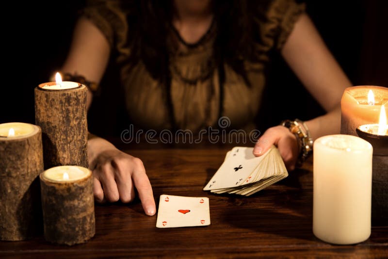 Female psychic is telling the future with playing cards, concept tarot and numerology. Female psychic is telling the future with playing cards, concept tarot and numerology