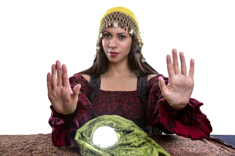 Female psychic or fortune teller with her hands up telling viewer to stop or rejecting. She is isolated on a white background with a crystal ball. Female psychic or fortune teller with her hands up telling viewer to stop or rejecting. She is isolated on a white background with a crystal ball