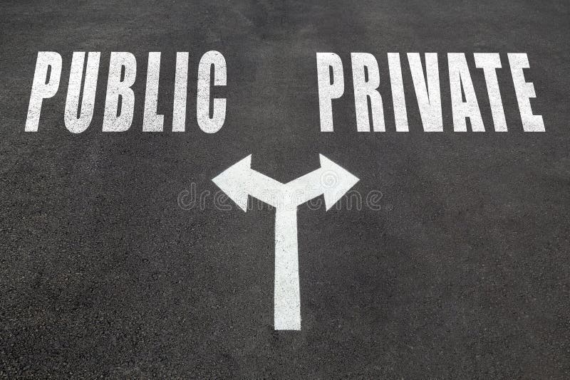 Public vs private choice concept, two direction arrows on asphalt. Public vs private choice concept, two direction arrows on asphalt.