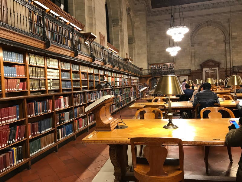 Public library, tables with lamps and shelves of books