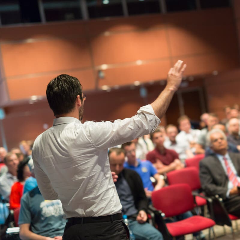 Public speaker giving talk at Business Event.