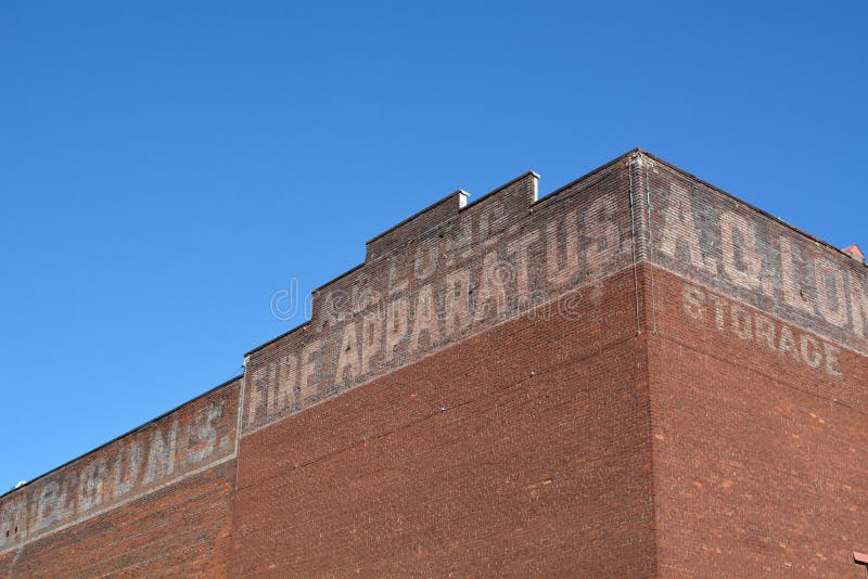 This is an older brick building in downtown Portland, Oregon with faded painted advertising against a blue sky. This is an older brick building in downtown Portland, Oregon with faded painted advertising against a blue sky.