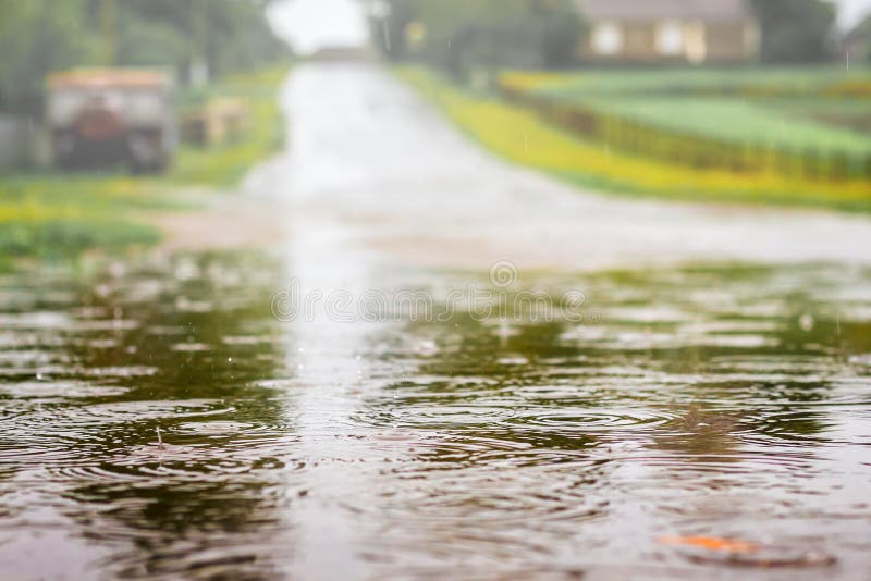 Puddle with water on the road during the shower. Strong rain on