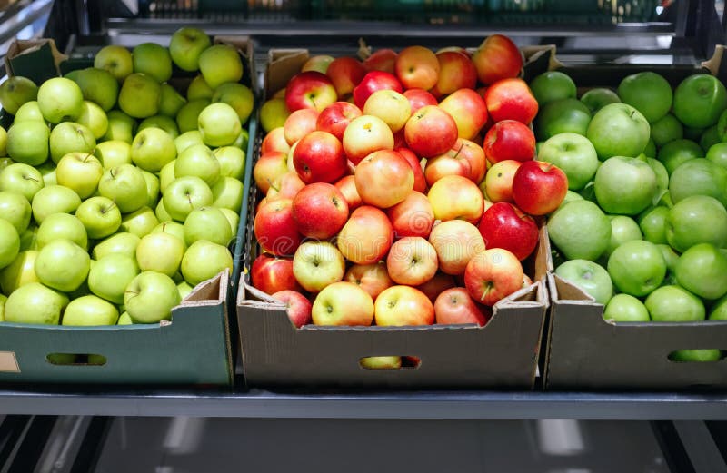 Boxes with ripe red and green apples on shelves of city supermarket. Boxes with ripe red and green apples on shelves of city supermarket