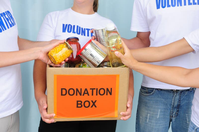 Volunteer putting food in a donation box. Volunteer putting food in a donation box