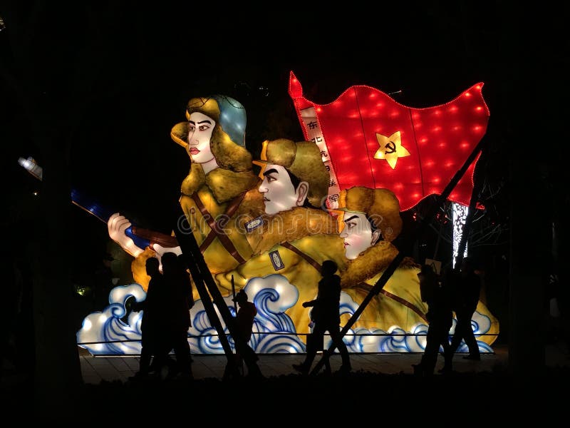 Pueblo chino que camina delante de una muestra iluminada del comunismo