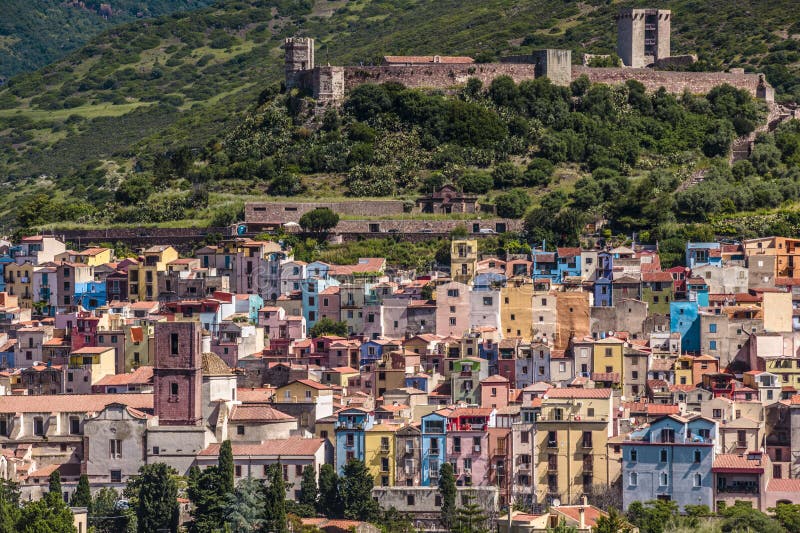 Pueblo hermoso de Bosa con las pequeñas casas y fortaleza coloridas, Cerdeña, Italia fotografía de archivo libre de regalías Pueblo hermoso de Bosa con las pequeñas casas y fortaleza coloridas, Cerdeña, Italia fotografía de archivo libre de regalías