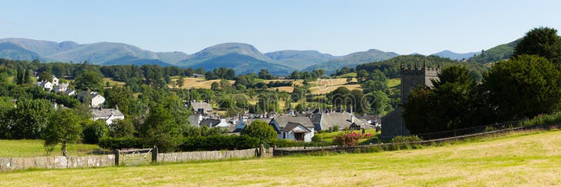 Pueblo inglés hermoso del país del distrito Cumbria Reino Unido del lago Hawkshead en verano con panorama de la iglesia del cielo fotografía de archivo libre de regalías Pueblo inglés hermoso del país del distrito Cumbria Reino Unido del lago Hawkshead en verano con panorama de la iglesia del cielo fotografía de archivo libre de regalías