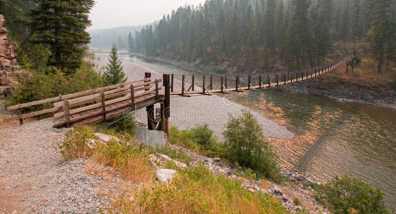 Puente colgante sobre el río de cabeza llana en la estación/el camping manchados del guardabosques del oso en Montana los E.E.U.U imagen de archivo Puente colgante sobre el río de cabeza llana en la estación/el camping manchados del guardabosques del oso en Montana los E.E.U.U imagen de archivo