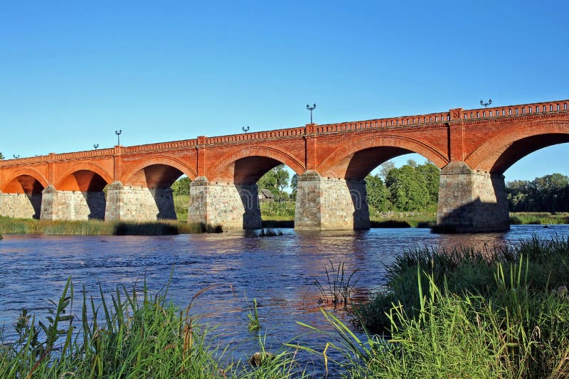 Puente del ladrillo a través del río Venta en Kuldiga, Letonia foto de archivo Puente del ladrillo a través del río Venta en Kuldiga, Letonia foto de archivo