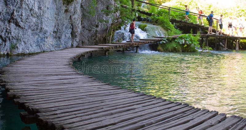 Puente a través del lago en bosque profundo. Agua cristalina. Plitvic