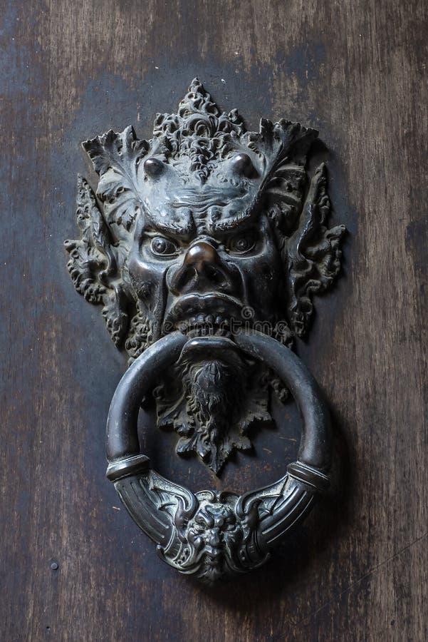 Puerta de bronce del golpeador de la cabeza del diablo imagen de archivo Puerta de bronce del golpeador de la cabeza del diablo imagen de archivo