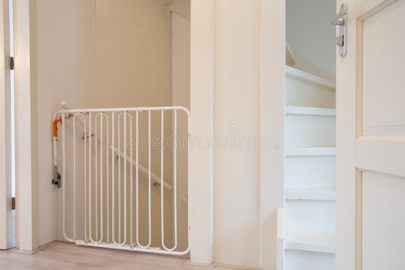 Puerta protectora blanca de seguridad para escaleras de bebé en el pasillo  escalera nueva y moderna valla de casa para niños en una hermosa casa