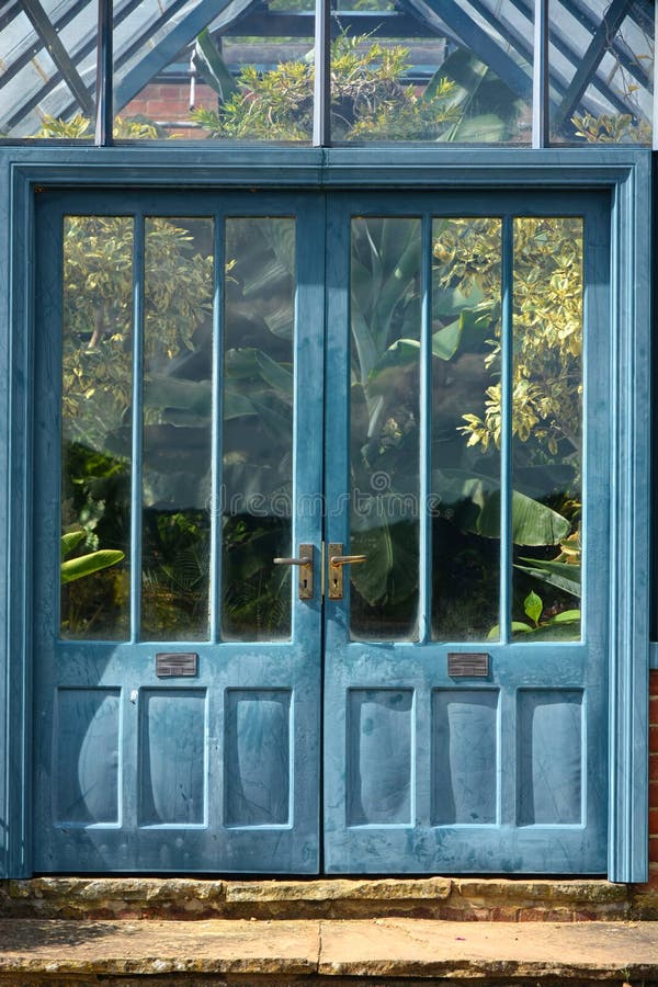 Puertas antiguas azules al invernadero tropical