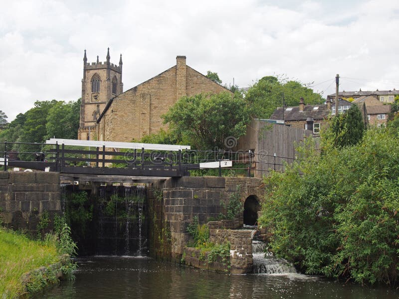 Puertas de esclusa en el canal en puente sowerby en West Yorkshire con la iglesia histórica de Cristo rodeada por los árboles imagen de archivo libre de regalías Puertas de esclusa en el canal en puente sowerby en West Yorkshire con la iglesia histórica de Cristo rodeada por los árboles imagen de archivo libre de regalías