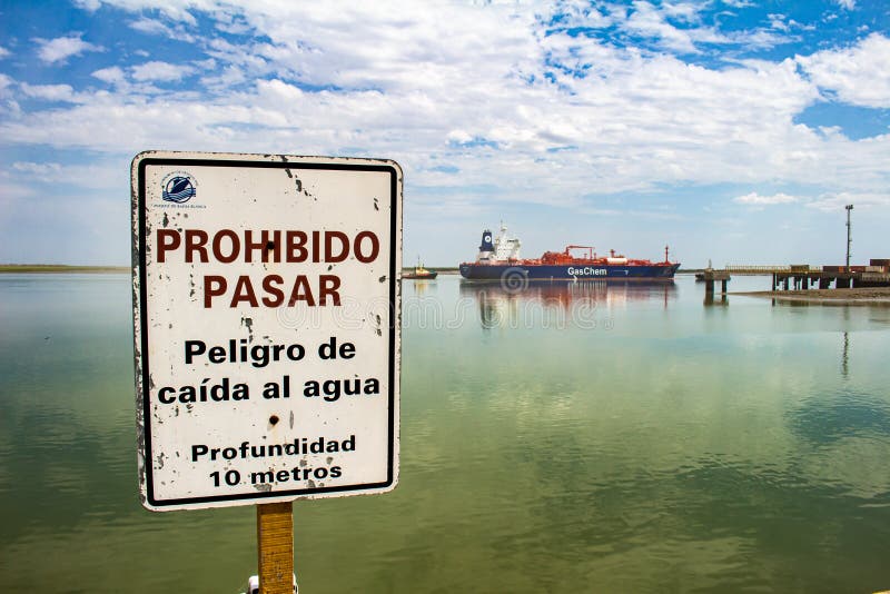 Buenos Aires. Argentina. February 3, 2018. Poster in the harbor of Bahía Blanca that indicates prohibited to pass. In the background a gas transporter ship. Buenos Aires. Argentina. February 3, 2018. Poster in the harbor of Bahía Blanca that indicates prohibited to pass. In the background a gas transporter ship