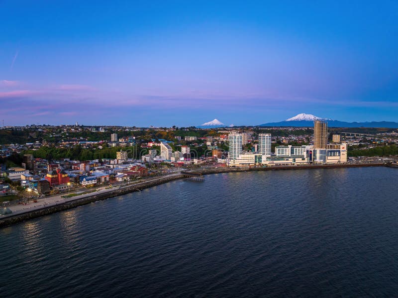 Puerto Montt cityscape med bergen Andes vid solnedgången. royaltyfri fotografi